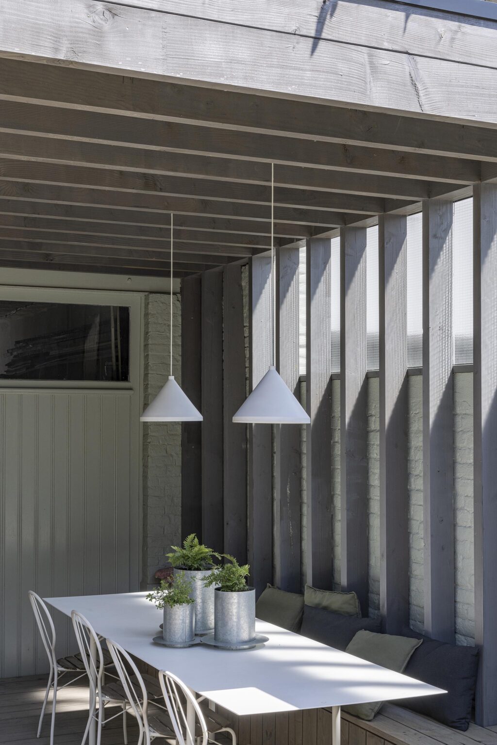 Salle à manger extérieure couverte avec suspensions design.